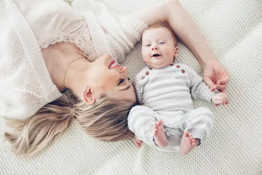 Maman allongée avec son bébé souriant