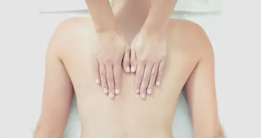 Mains pratiquant un massage du dos